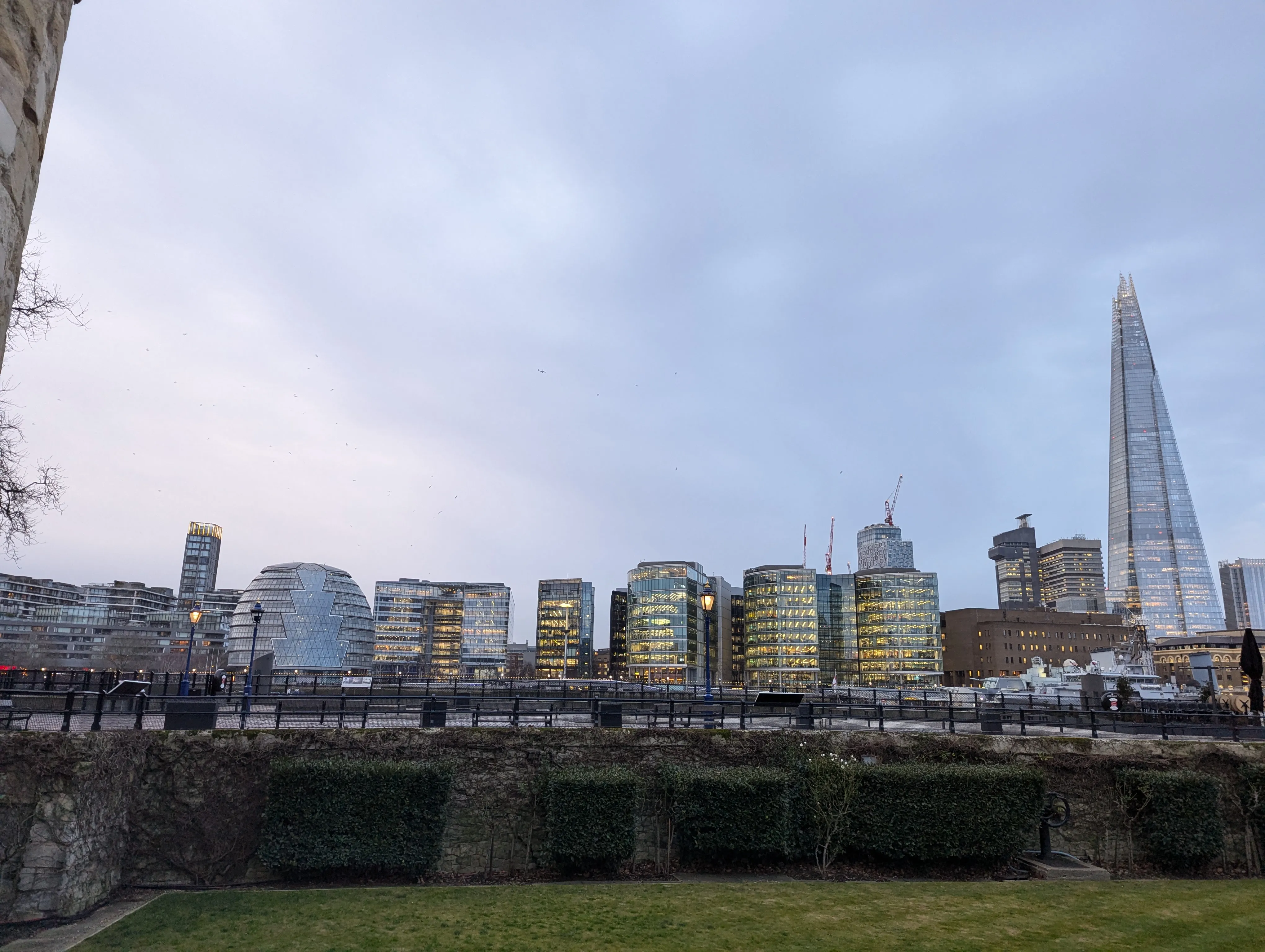 Tall, glass & metal building across the river