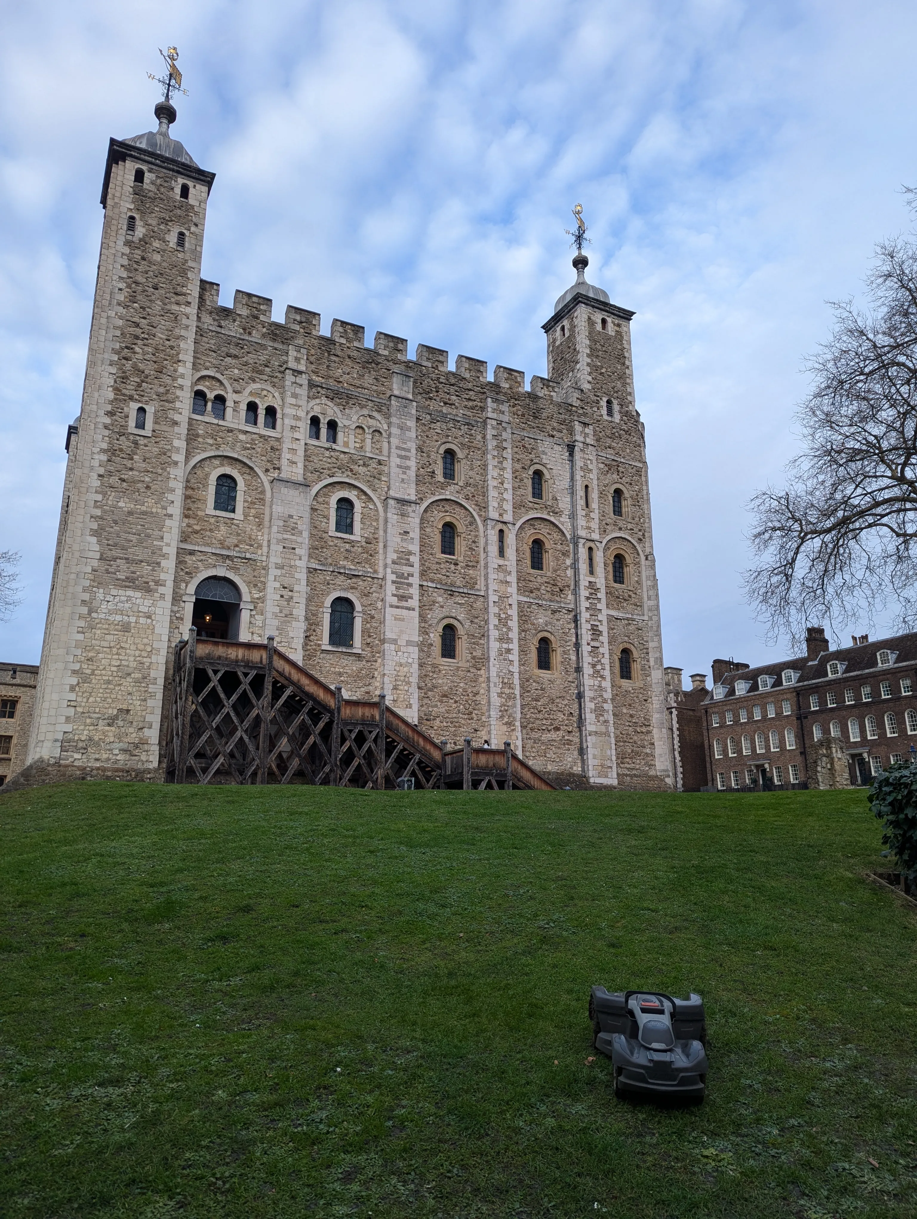 lawn roomba on the grass in front of the white tower
